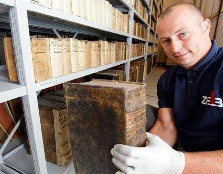 © Stefan Sauer/dpa - Dirk Thomas, Mitarbeiter des Zentrum für Bucherhaltung, packt in der Bibliothek des Stadtarchivs von Stralsund eine Bibel aus dem 16. Jahrhundert in einen Transportkarton, in dem sie zur Restaurierung gebracht wird . © Stefan Sauer/dpa - Dirk Thomas, Mitarbeiter des Zentrum für Bucherhaltung, packt in der Bibliothek des Stadtarchivs von Stralsund eine Bibel aus dem 16. Jahrhundert in einen Transportkarton, in dem sie zur Restaurierung gebracht wird .
