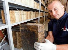 © Stefan Sauer/dpa - Dirk Thomas, Mitarbeiter des Zentrum für Bucherhaltung, packt in der Bibliothek des Stadtarchivs von Stralsund eine Bibel aus dem 16. Jahrhundert in einen Transportkarton, in dem sie zur Restaurierung gebracht wird .